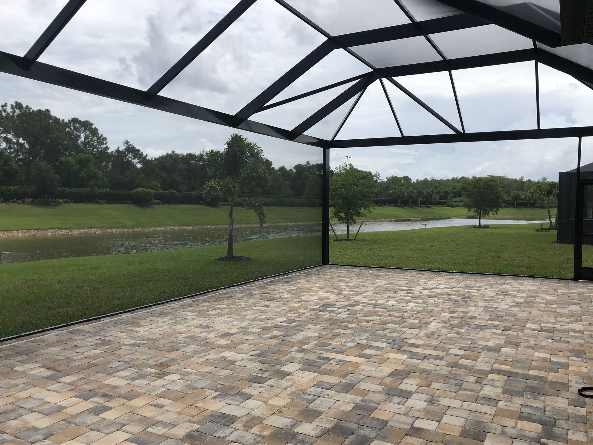 Screened porch with blue sectional, overlooking trees and sunlight.