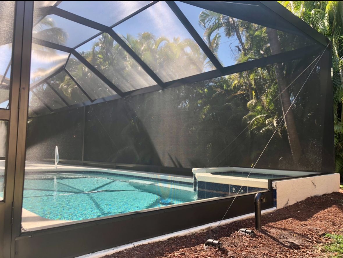 Brick-paved patio of a yellow brick house with a covered outdoor area and a smaller brick building.