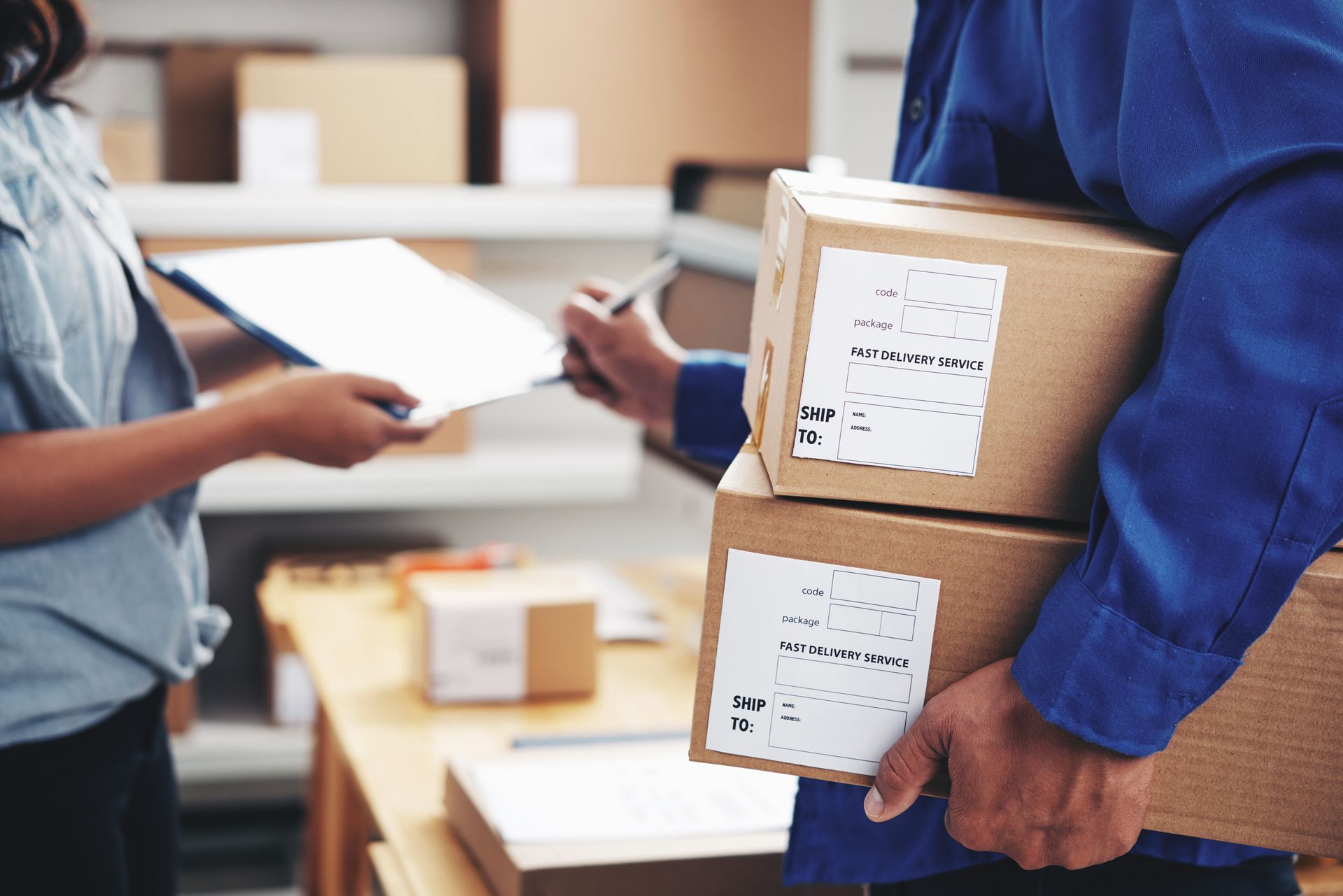 Person in blue uniform holding two labeled boxes