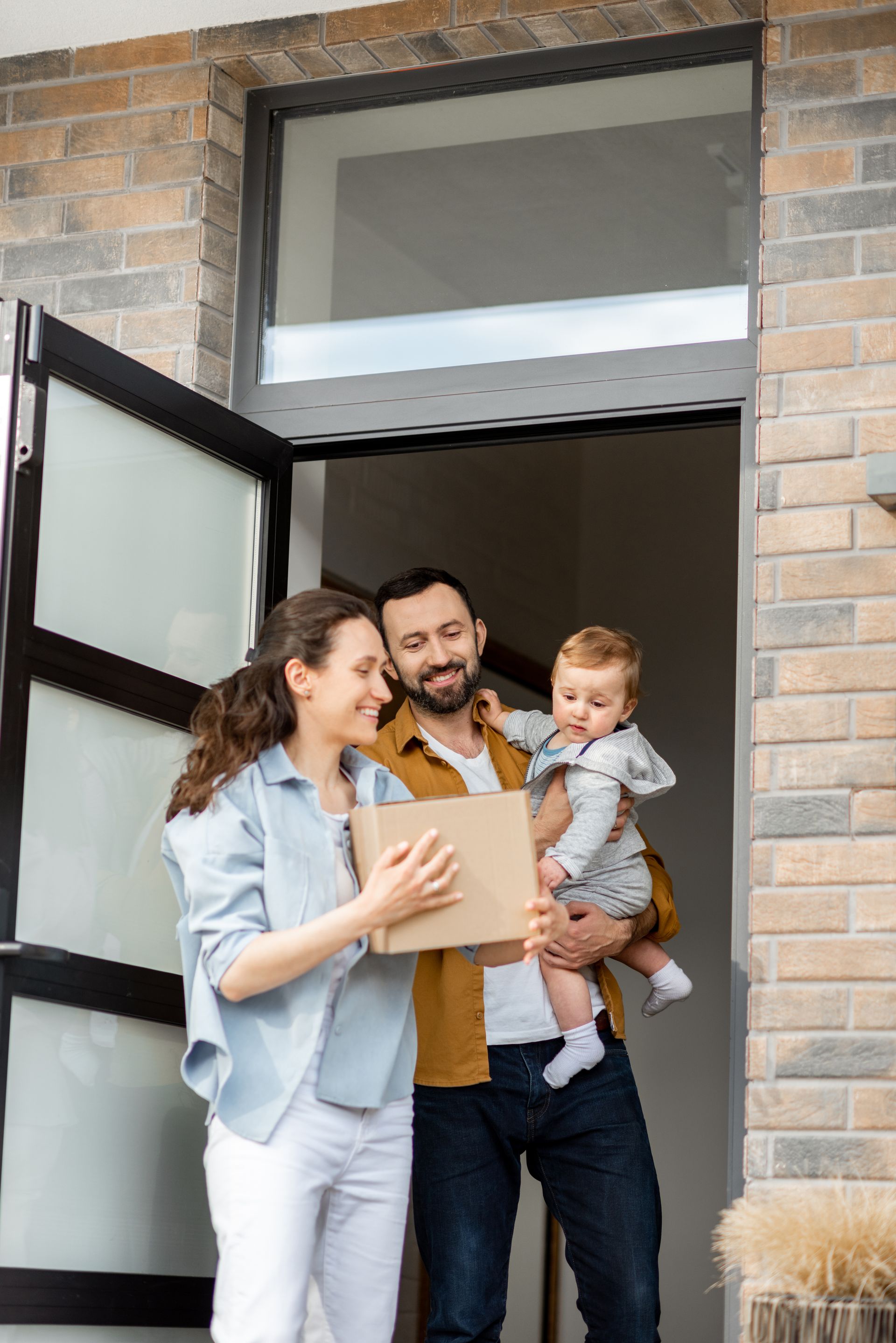 Family at doorway, holding package
