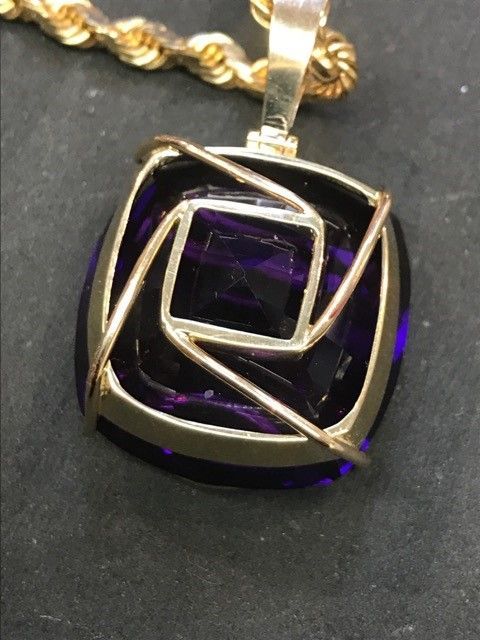 Purple square pendant with gold wire detailing and gold chain.