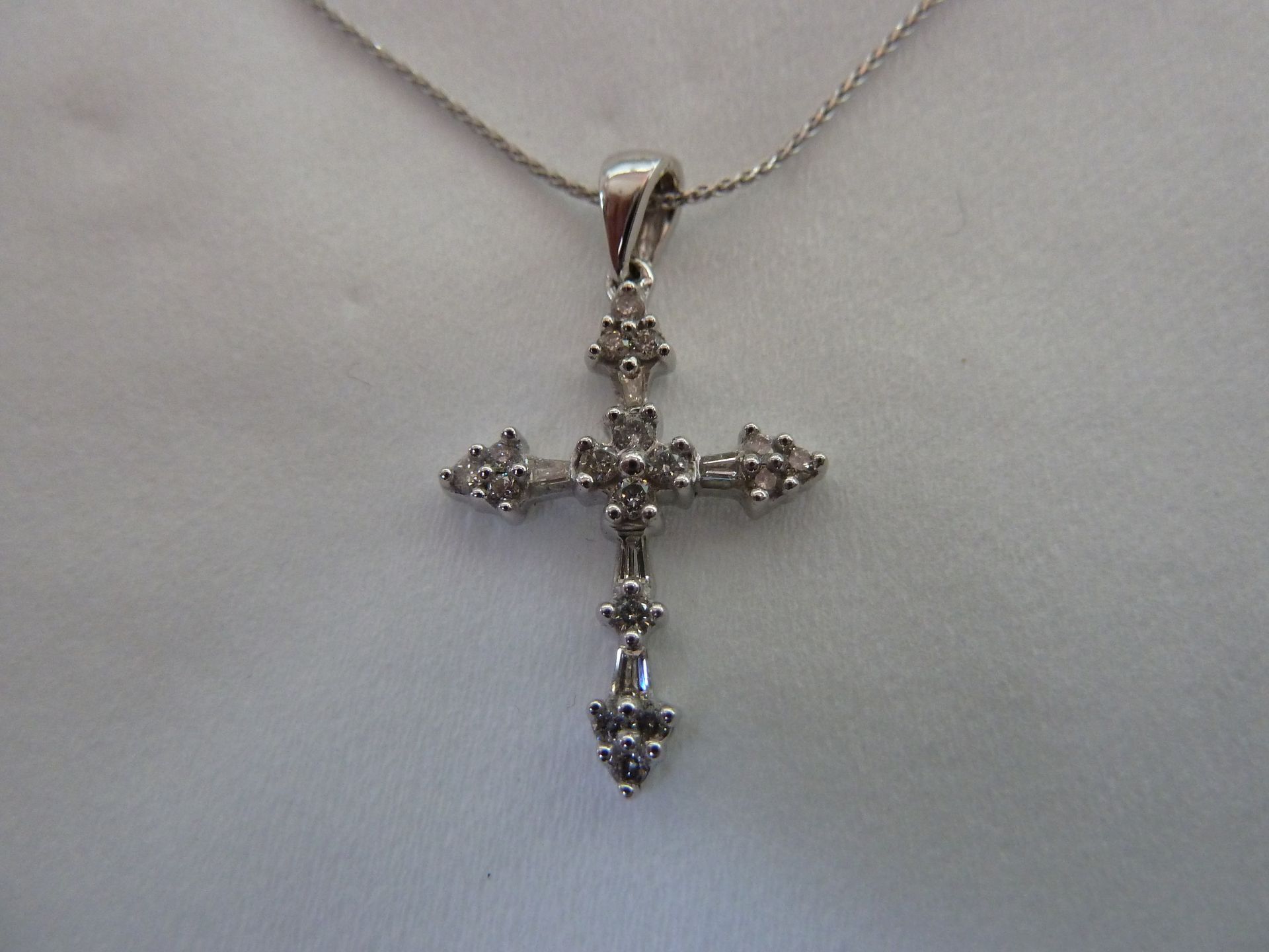 Diamond cross pendant on a silver chain.