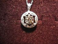 Diamond pendant necklace on a red velvet background.