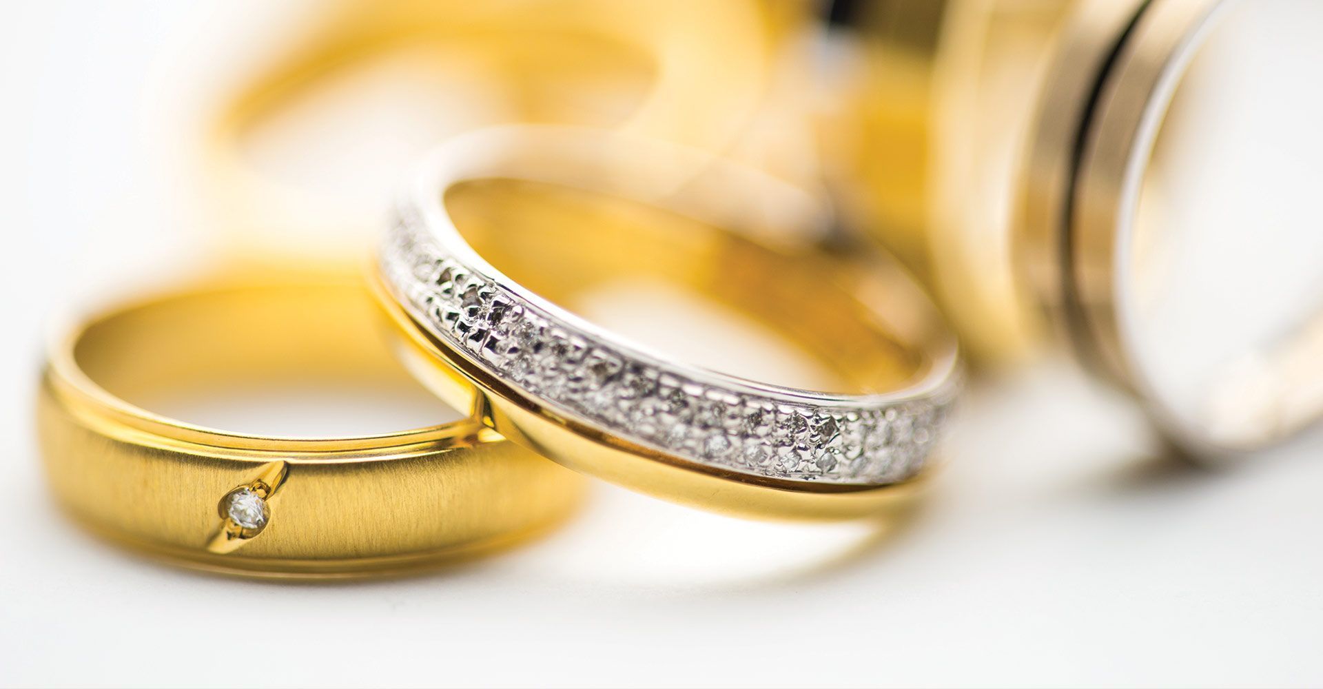 Close-up of gold rings, one with diamonds.