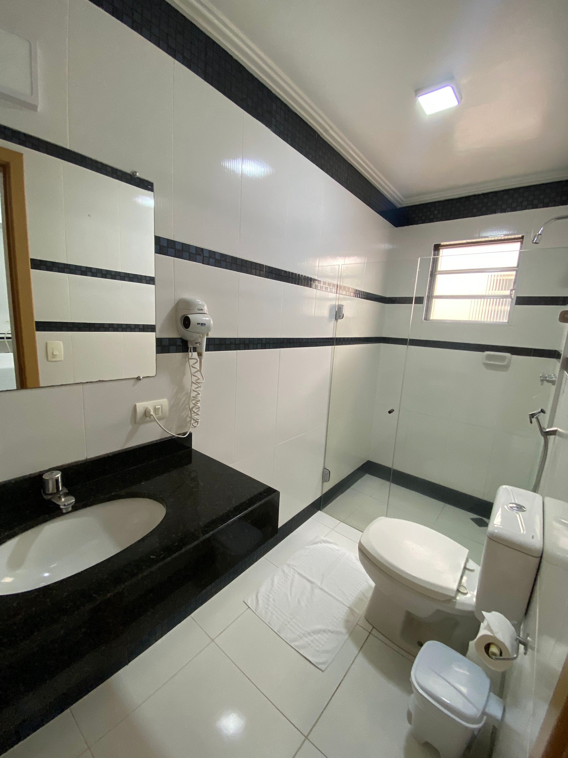 Um banheiro com um vaso sanitário, uma pia e um espelho