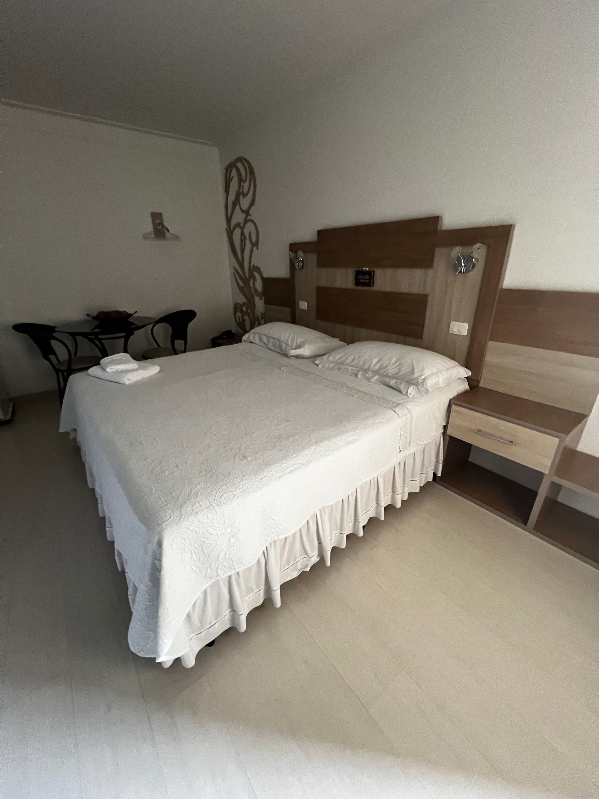 Há uma cama grande no meio do quarto.