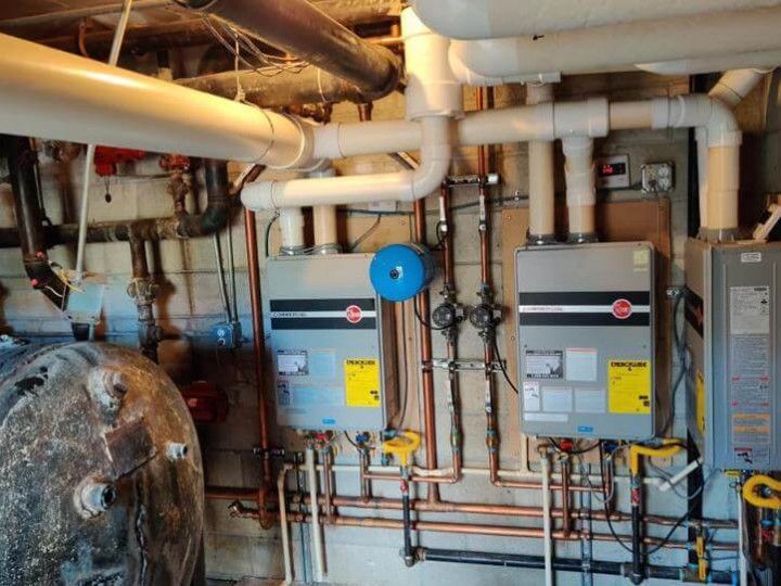 A plumber is working on a faucet with a wrench.