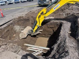 Two men are fixing a sink in a kitchen.