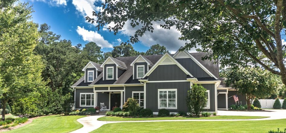 A large house with a lot of windows is surrounded by trees