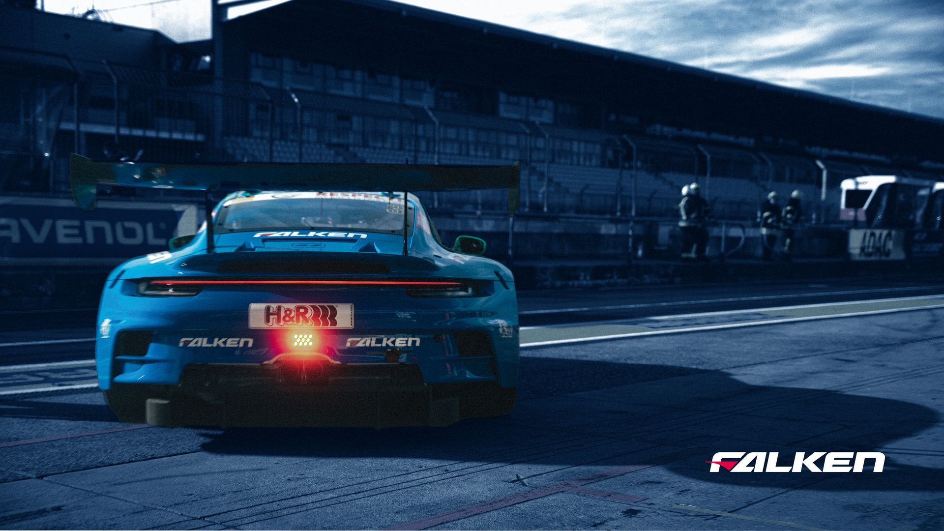 A person holding a handheld diagnostic scanner while inspecting a black car in an automotive garage.