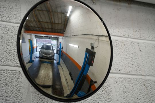 close up of an mot bay mirror showing a car been driven onto the MOT bay Ramp