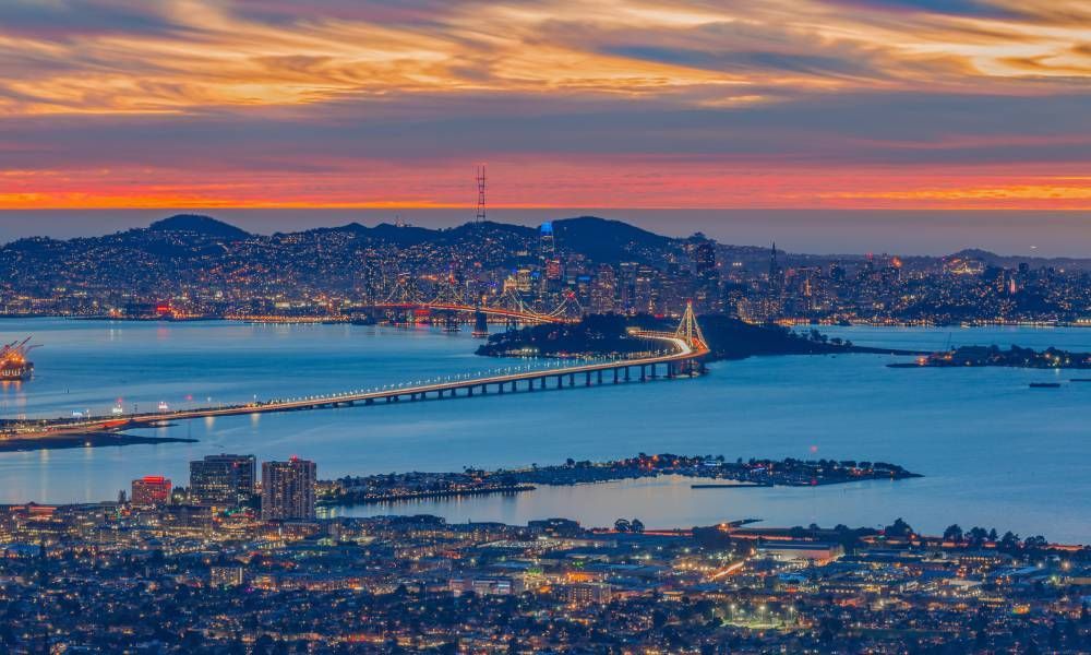 The San Francisco Bay Area during sunset with an array of vibrant oranges, pinks, and purples painting the sky