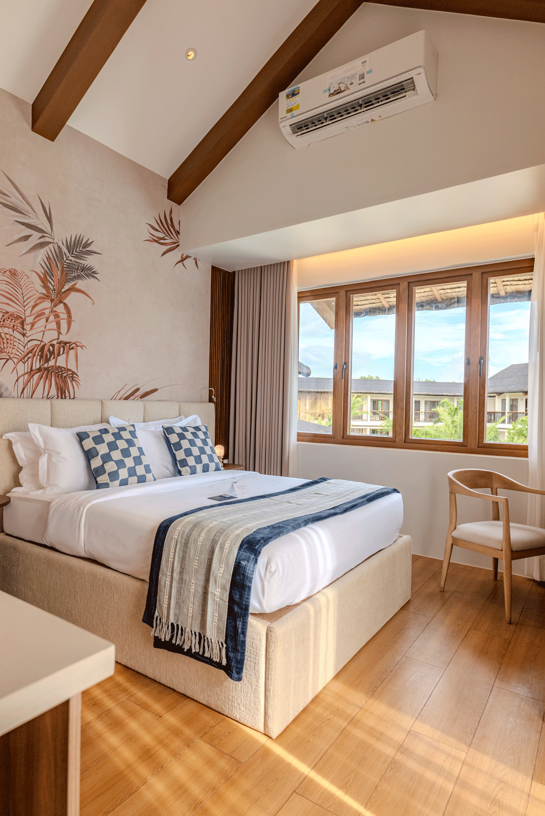 Bright tropical hotel room with king bed and pool view at Harvest Hotel Cab