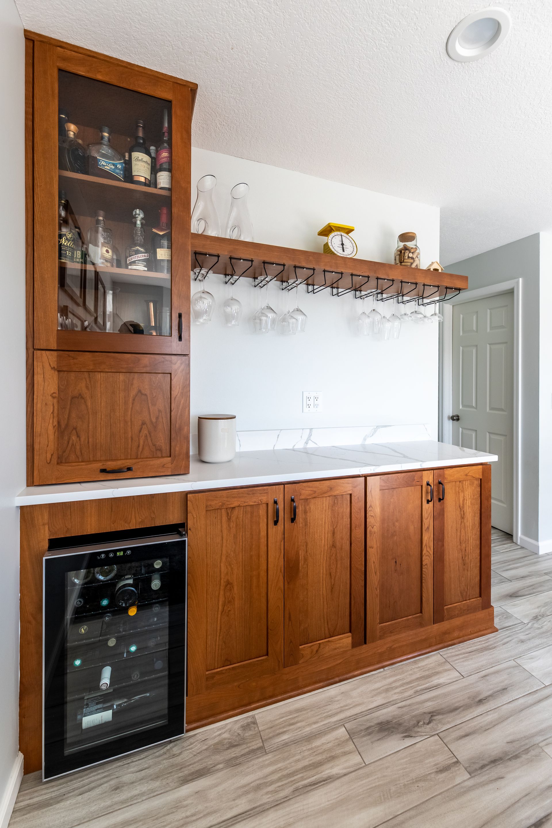 A kitchen with wooden cabinets and a wine cooler.