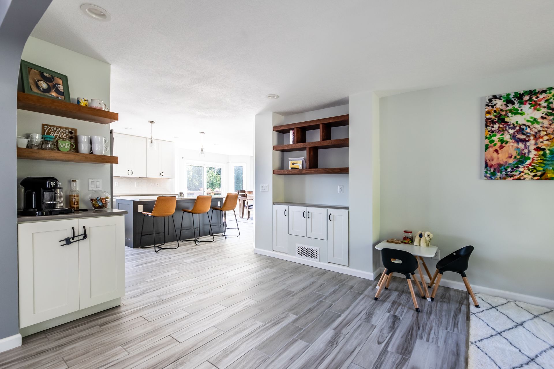 A remodeled kitchen with a table and chairs and a painting on the wall.