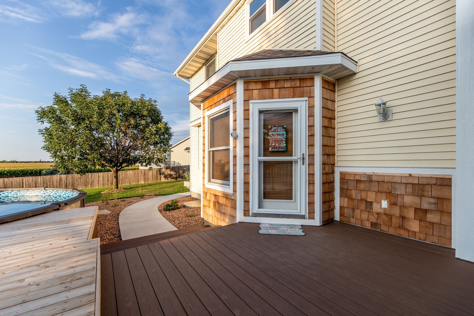 A house with a large deck and a hot tub in the backyard.