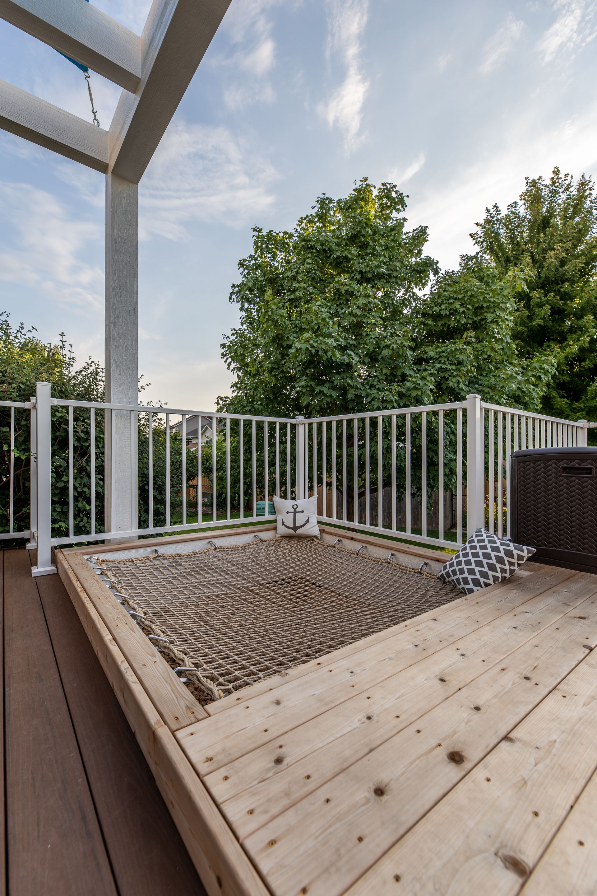 A wooden deck with a hot tub and a white railing.