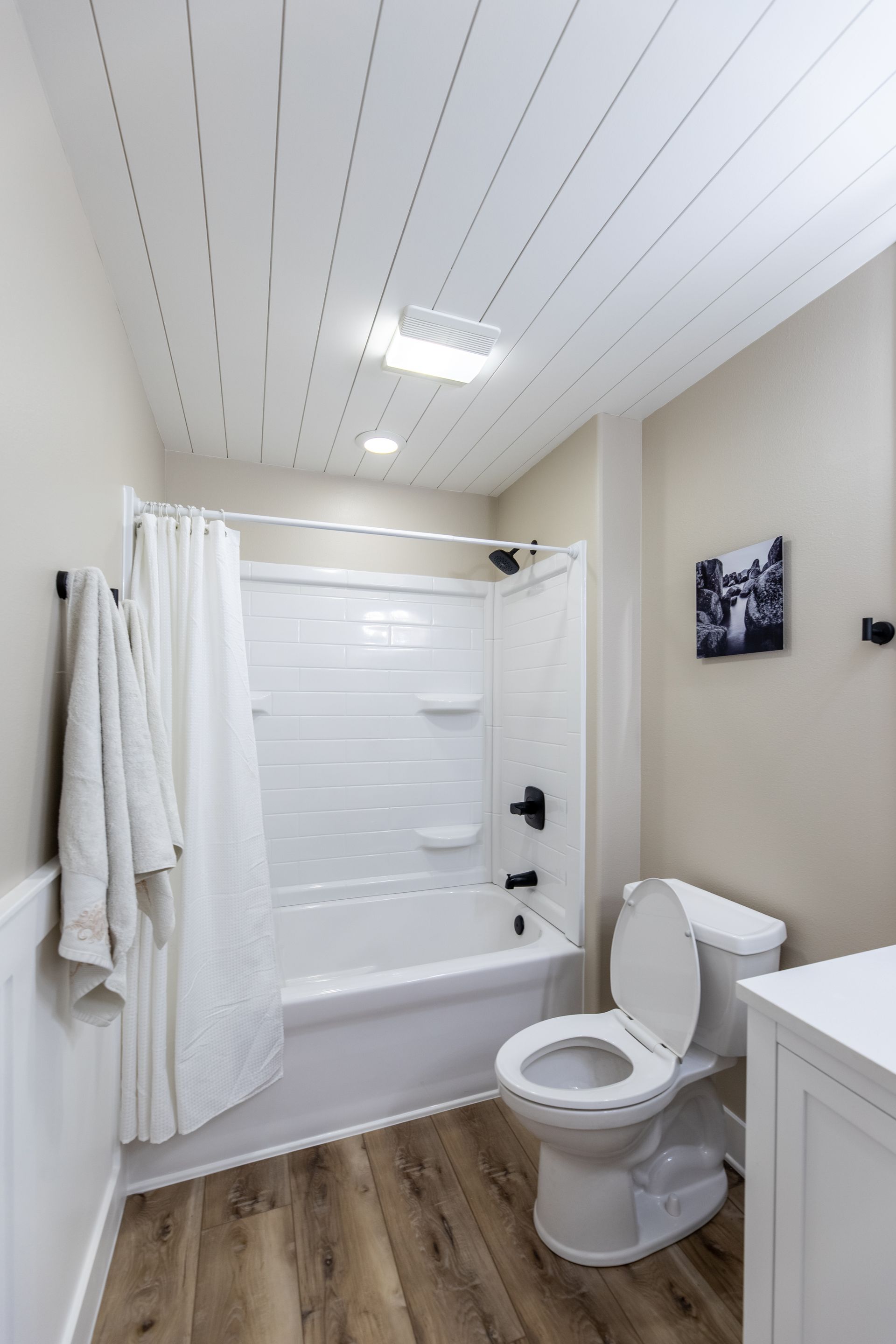 A bathroom with a toilet , bathtub and shower.