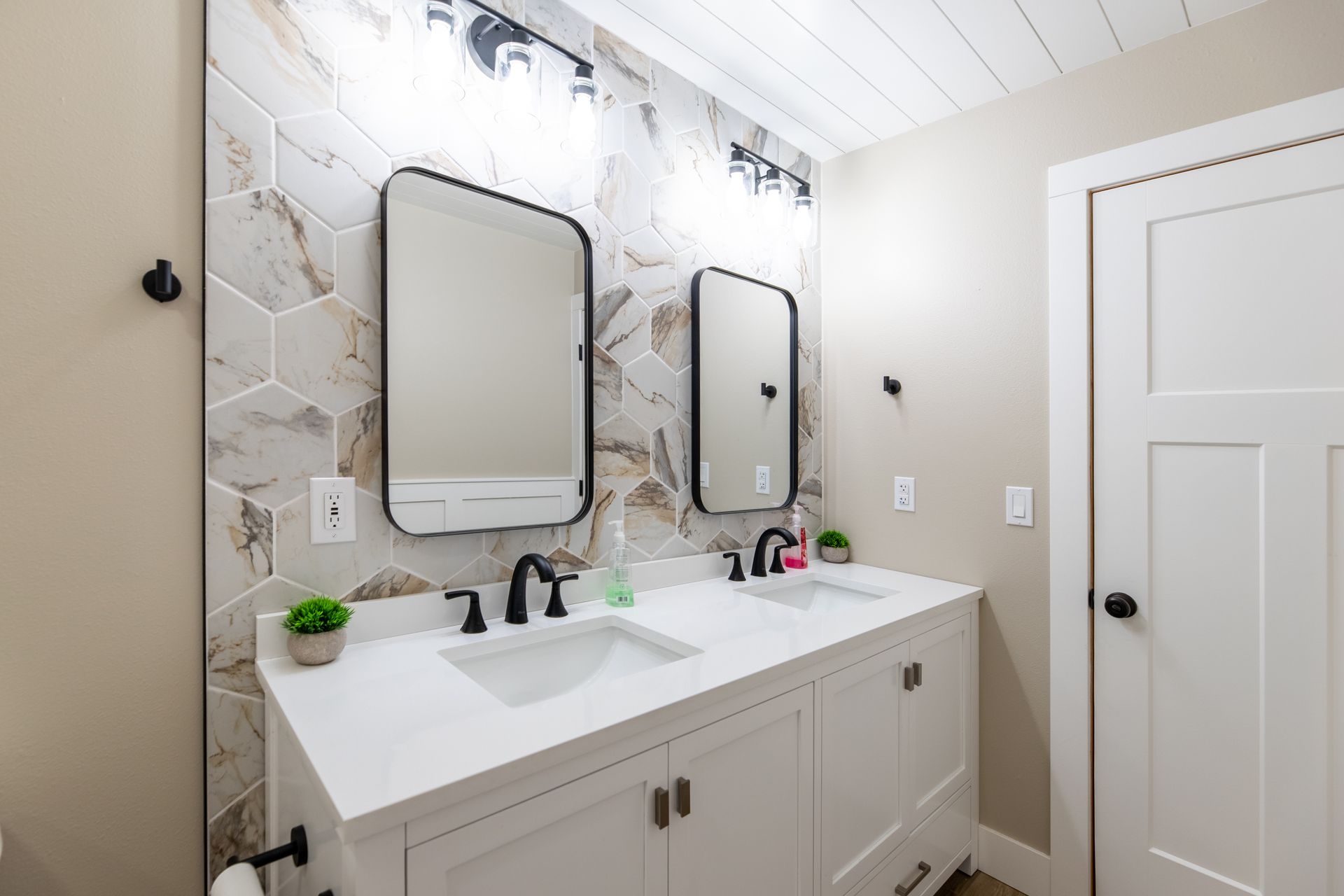 A bathroom with two sinks and two mirrors.