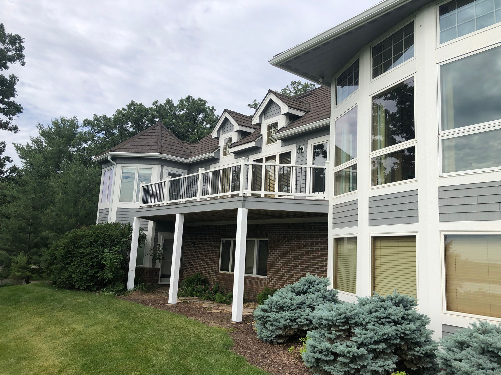A large house with a large deck and lots of windows