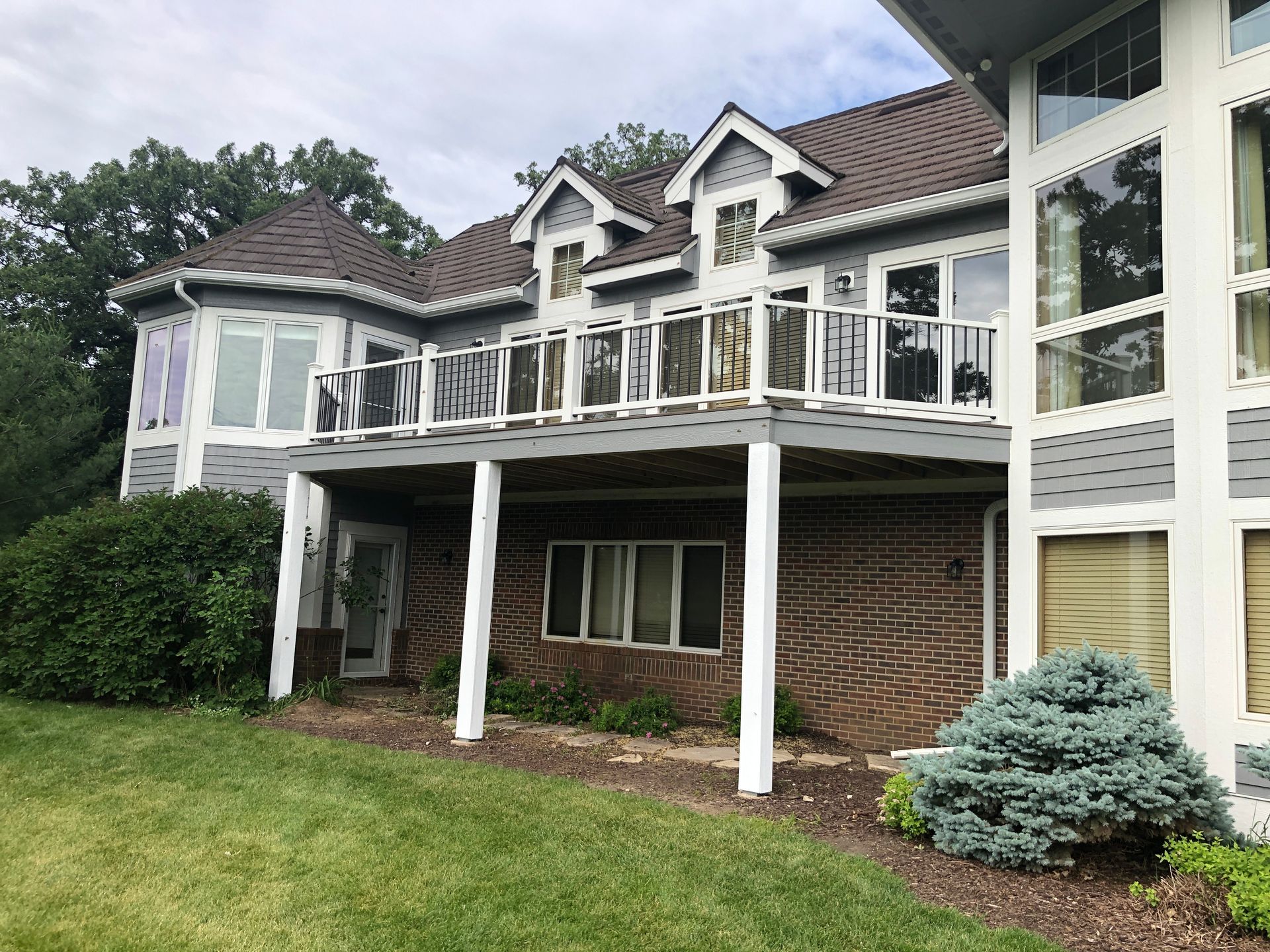 A large house with a large deck and a lot of windows.