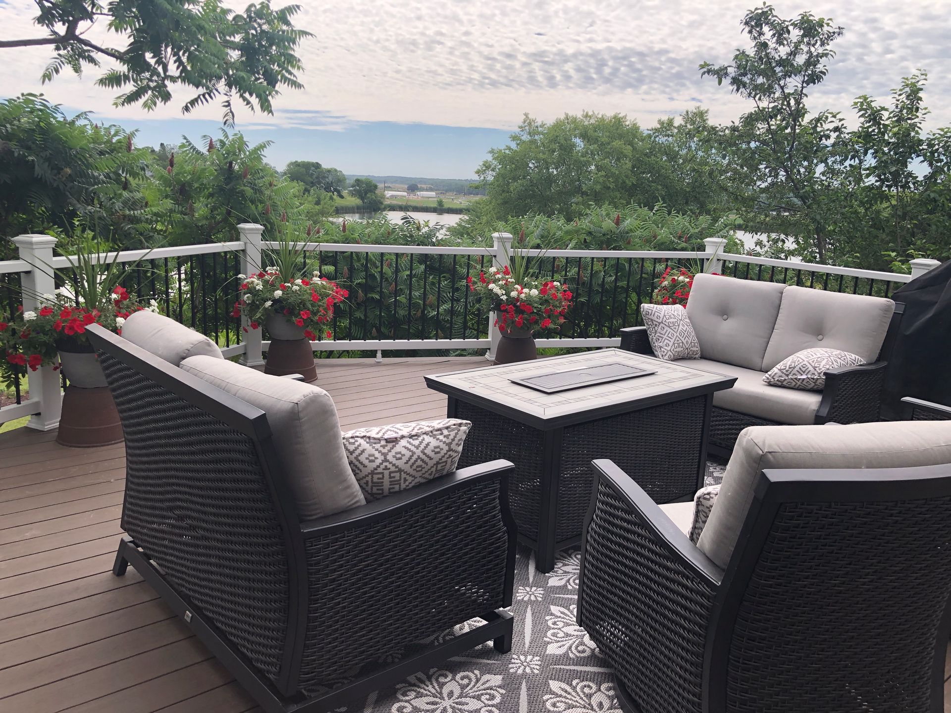 A deck with wicker furniture and a fire pit