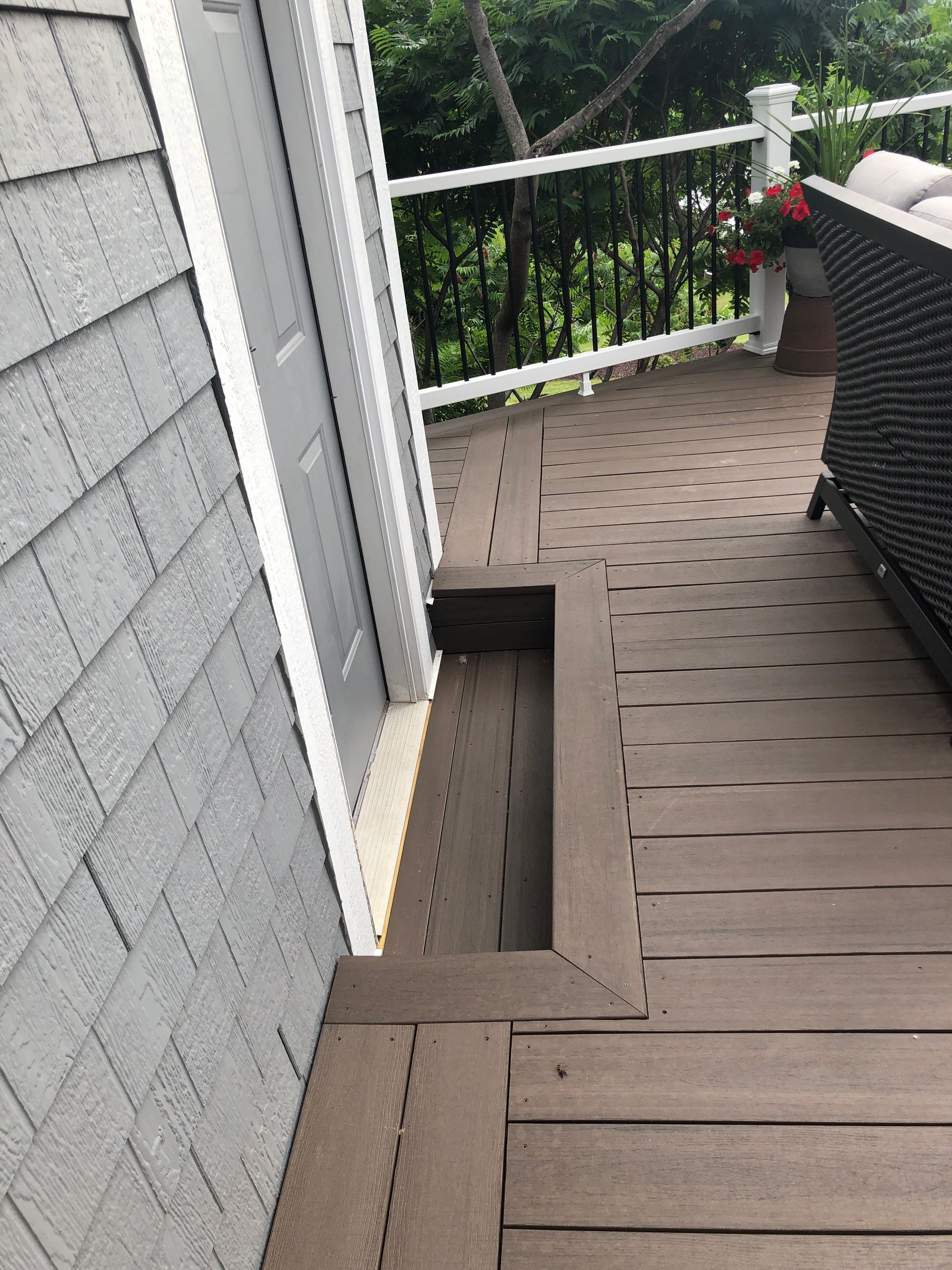 A wooden deck with stairs leading up to it next to a house.