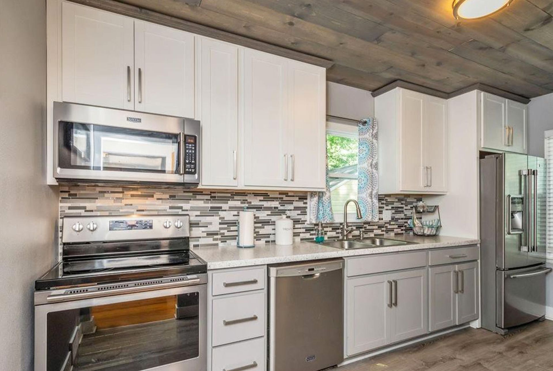 A kitchen with white cabinets and stainless steel appliances.