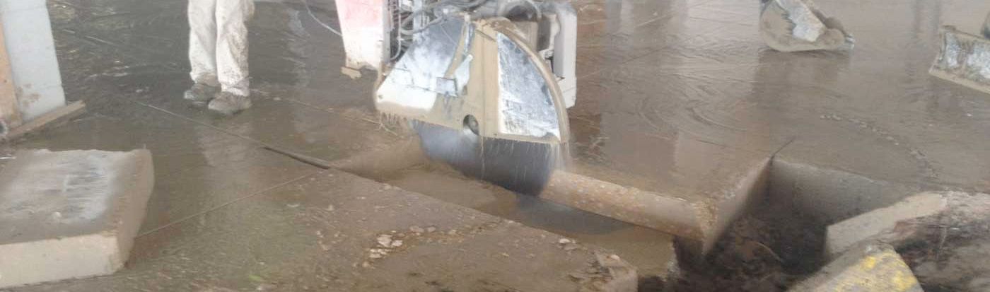 A machine is cutting a piece of concrete in a room.