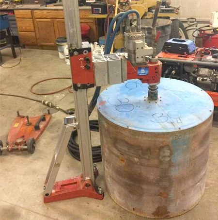 A machine is cutting a large piece of metal in a garage.