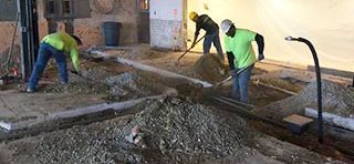 A man is pouring oil into a car through a funnel.