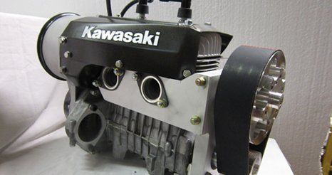 Kawasaki engine with black casing, silver details, and a large belt.