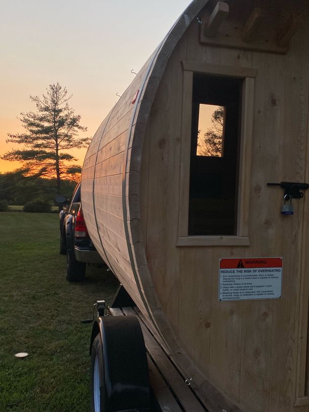 A wooden barrel on a trailer. Mobile sauna