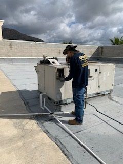 Man working On Air Conditioner On The Roof - Los Angeles, CA - Gomez Electric Inc