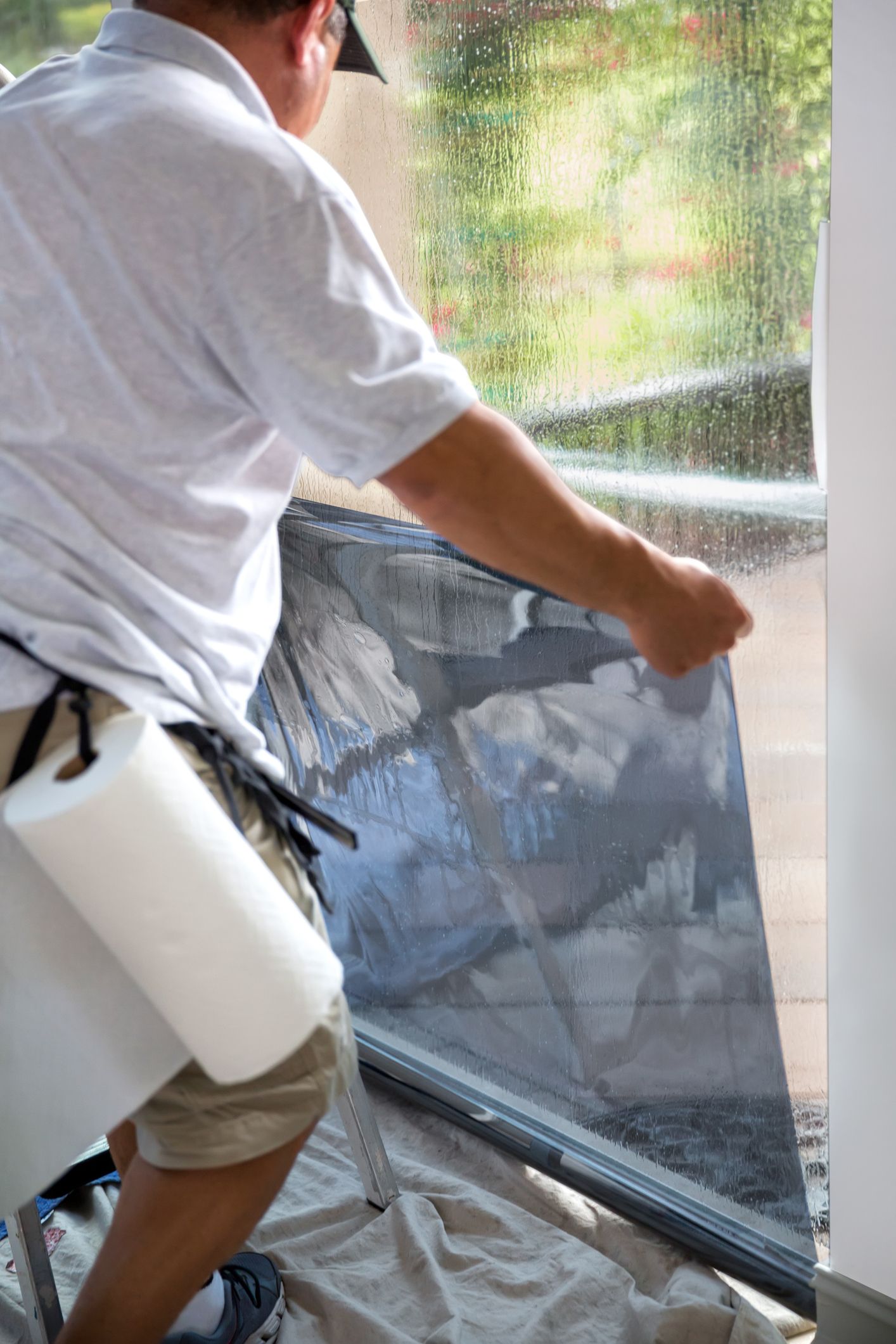 A window contractor applies a window tint to a window.