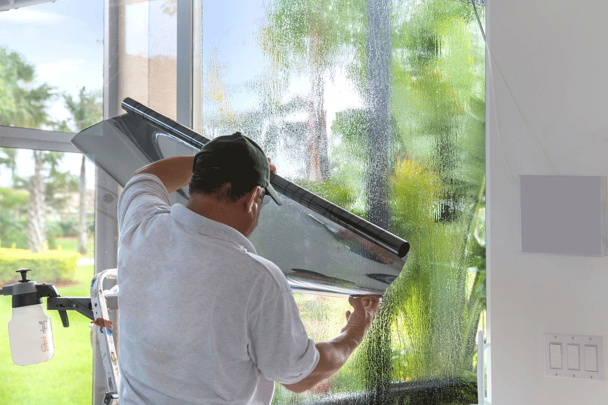 Professional window tinting process in a workshop using high quality film.