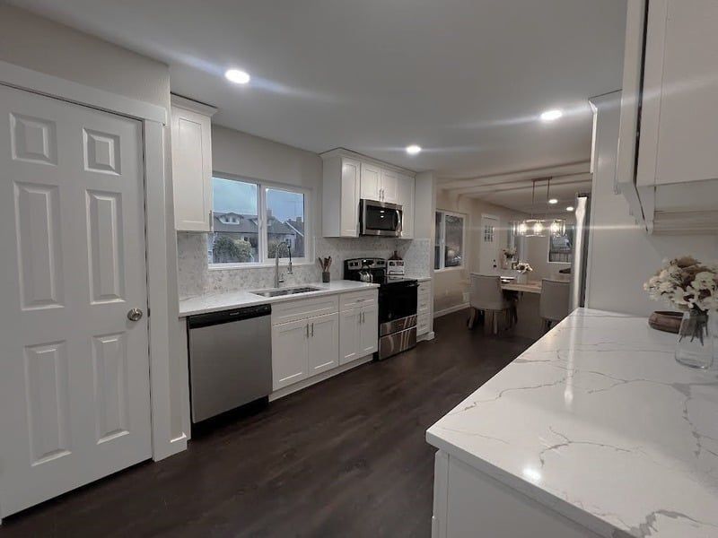 A kitchen with white cabinets and stainless steel appliances.