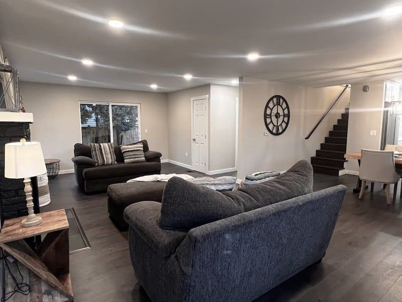A living room filled with furniture and a clock on the wall.