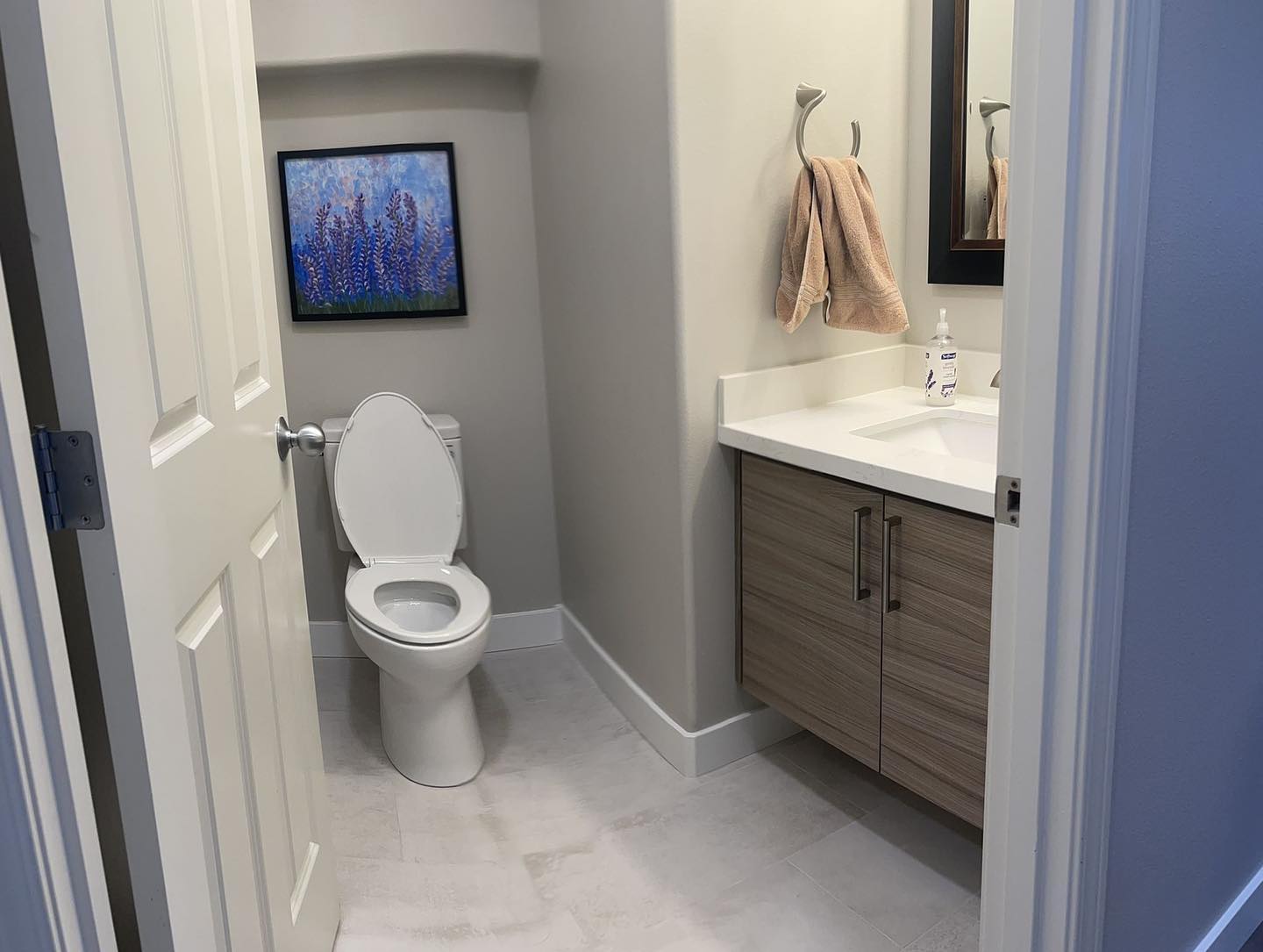 A bathroom with a toilet , sink and mirror.