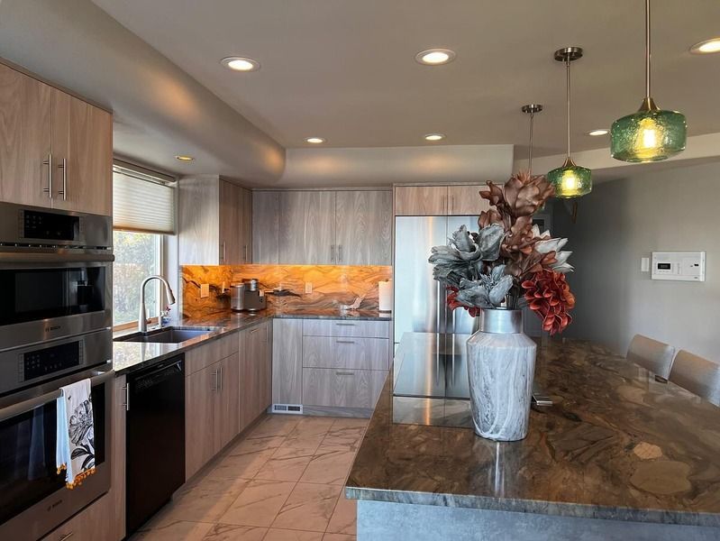 Modern kitchen with wood cabinets, stainless steel appliances, and granite countertops.