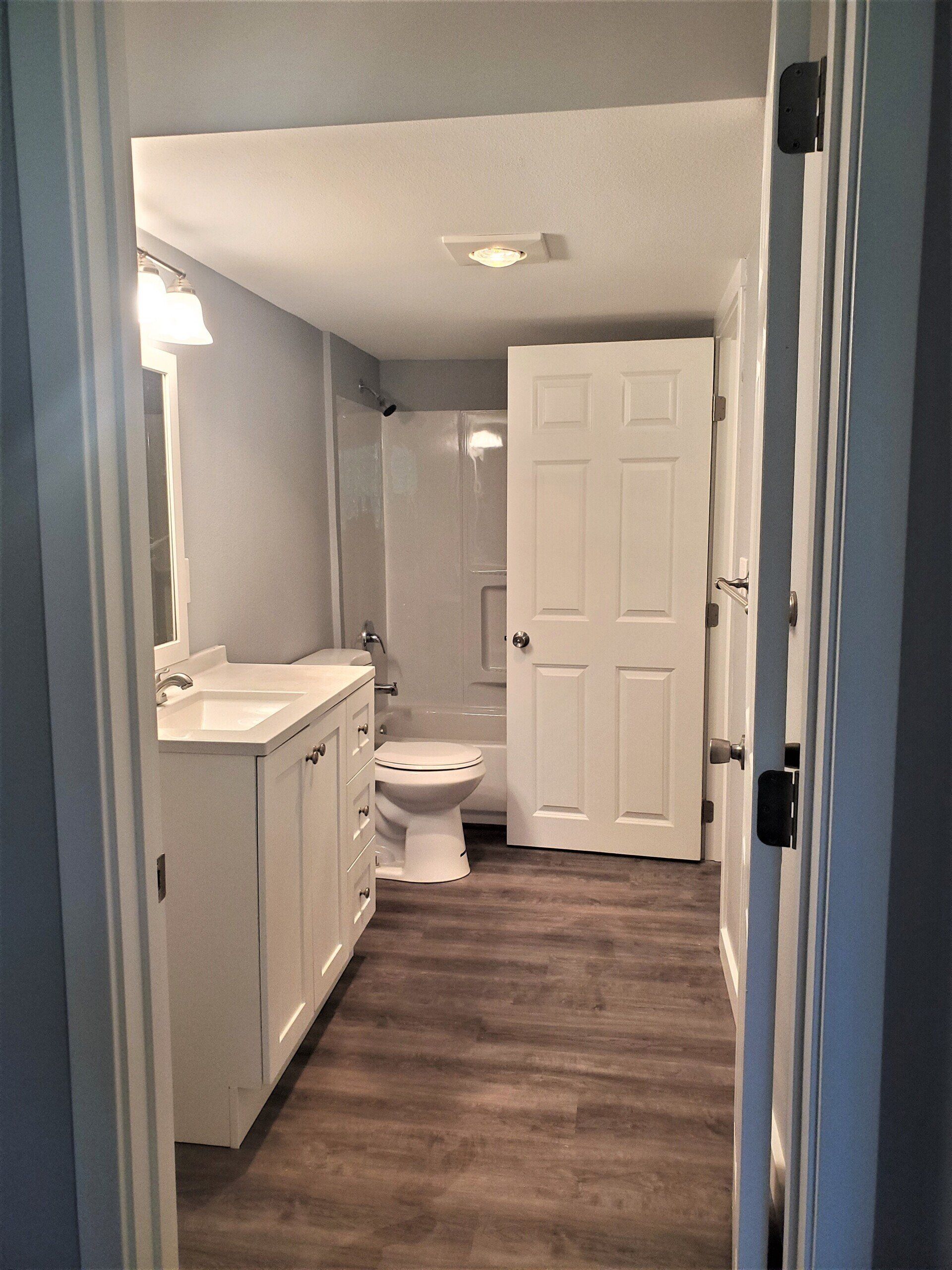 A bathroom with a toilet , sink , and shower.