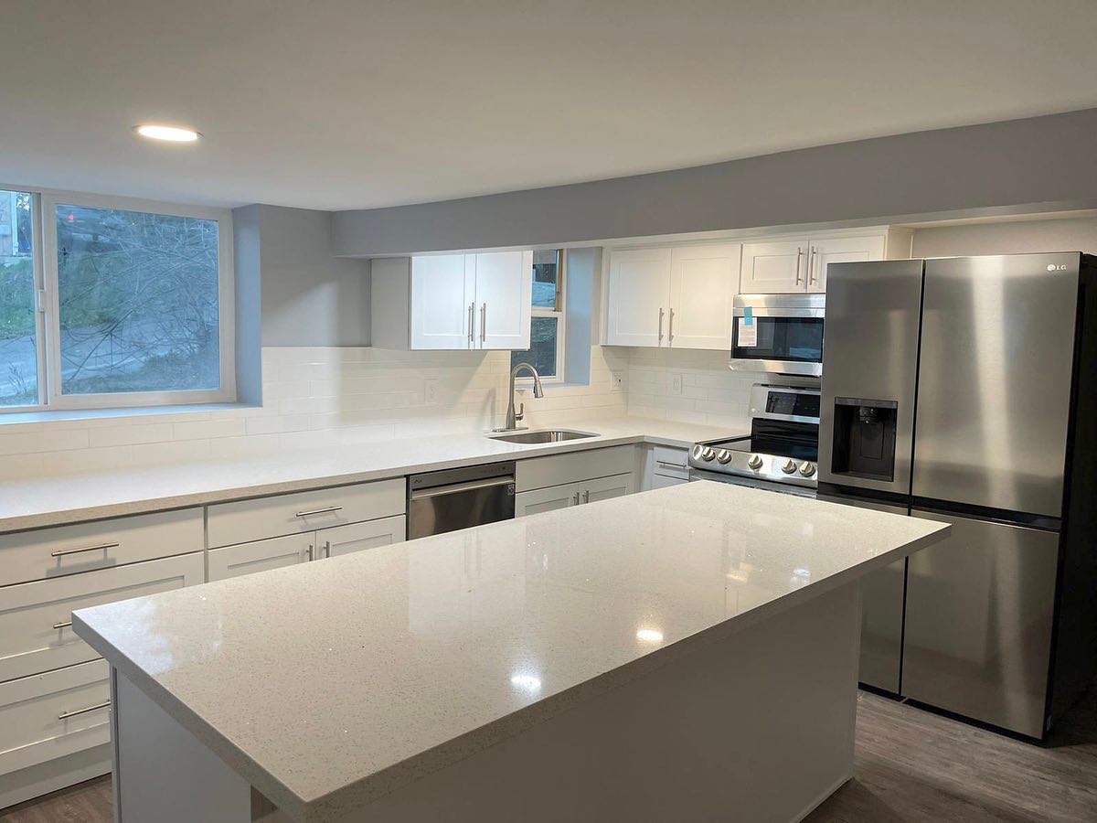 A kitchen with stainless steel appliances and white cabinets