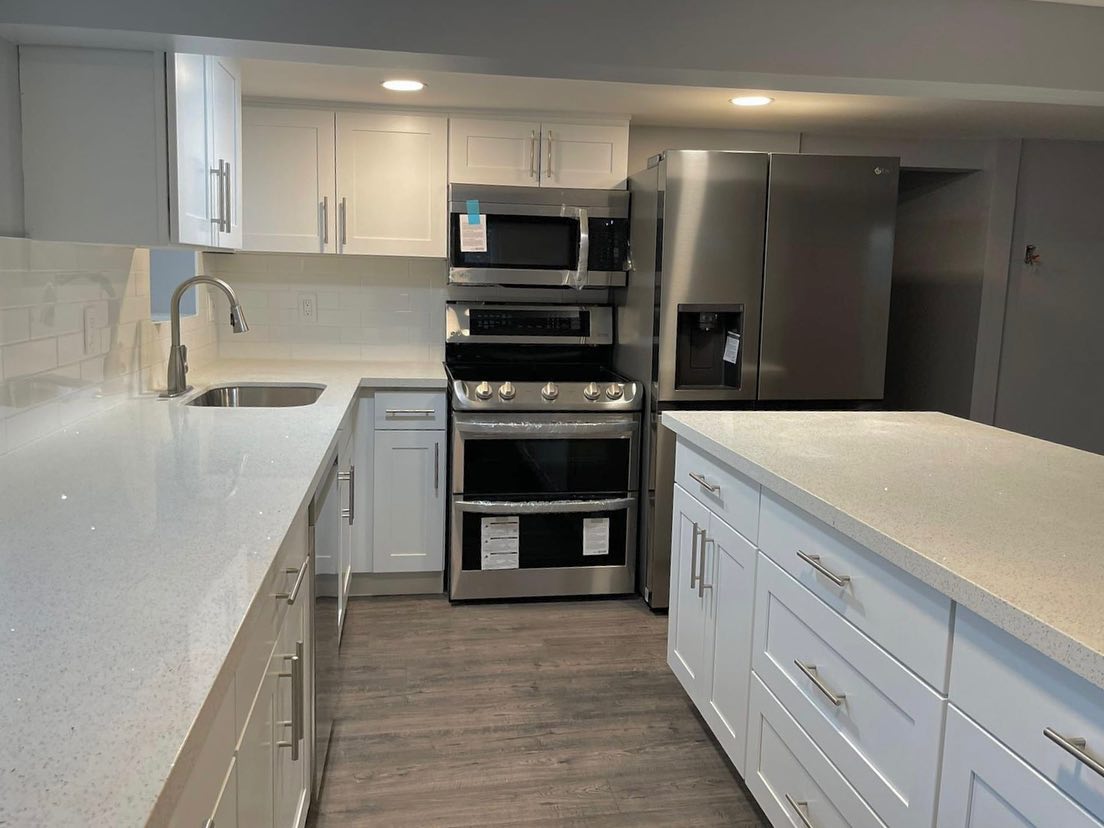 A kitchen with white cabinets and stainless steel appliances