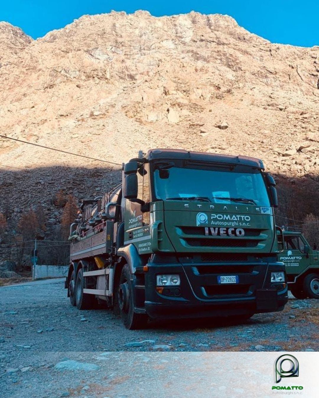 Un camion IVECO verde su una strada in un ambiente montano. Il camion ha il logo 