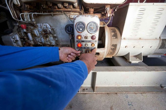 A man in a blue shirt is working on a machine.