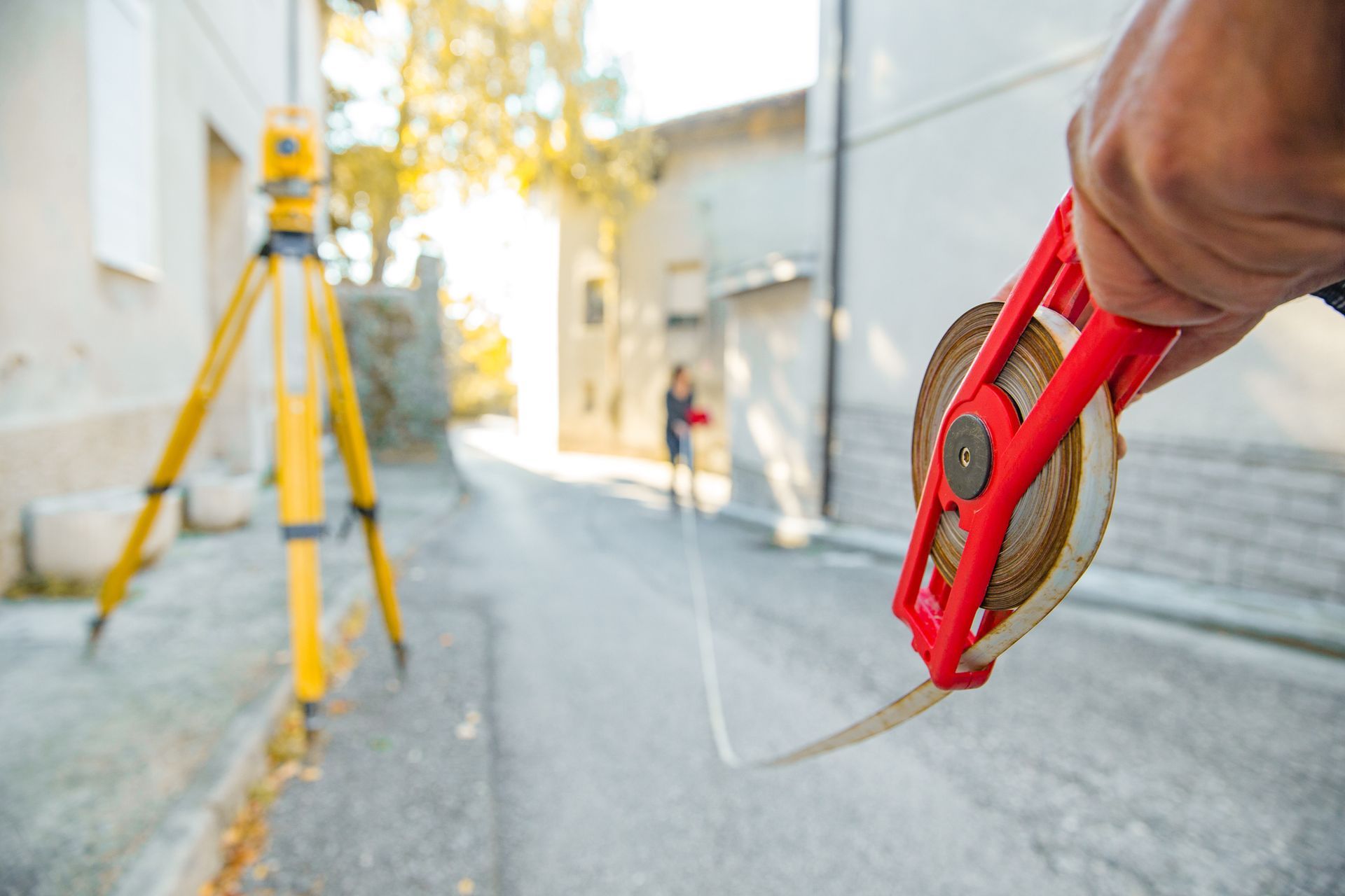 A man is standing in the dirt next to a tripod.