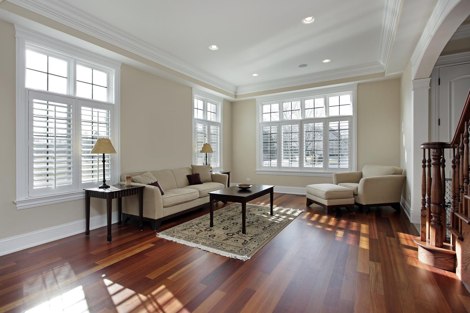 A living room with hardwood floors , a couch , chairs , and a coffee table.