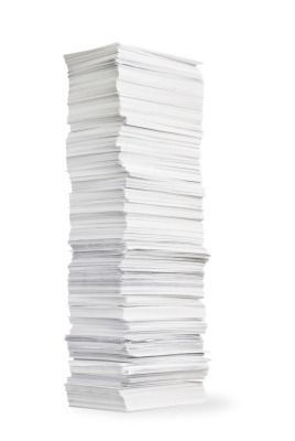 A tall stack of white papers on a white background.