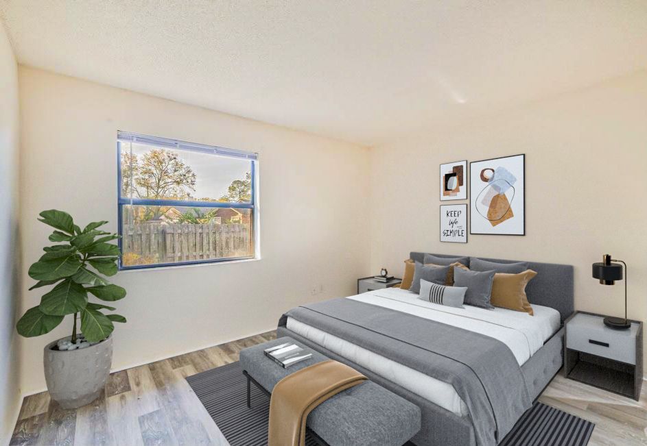 Photo of a bedroom with a large bed and still plenty of open space, as well as plenty of natural lighting