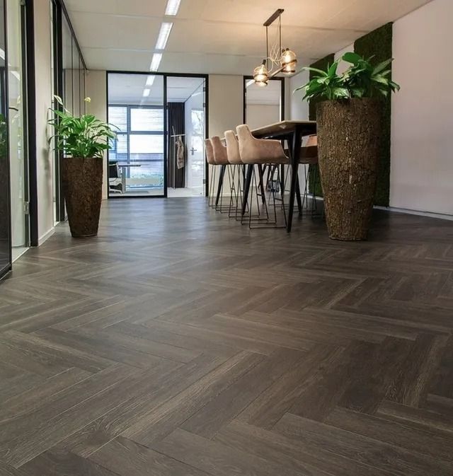 Groene kunstgrasmatten opgestapeld op houten planken in een winkelpresentatie.